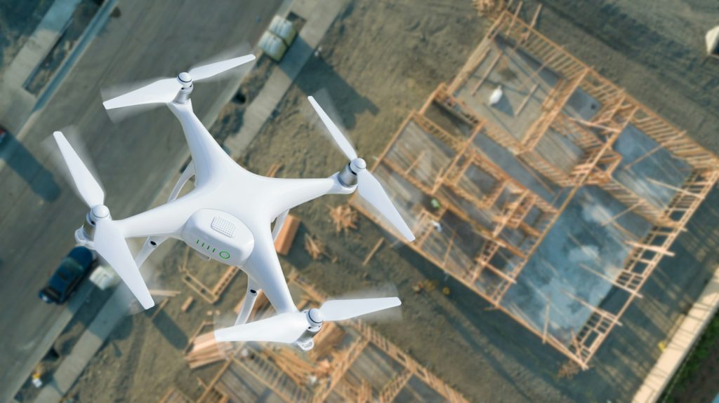 Unmanned Aircraft System (UAV) Quadcopter Drone In The Air Over Construction Site.-Cómo los Drones Están Transformando la Industria de la Construcción - RoCDrone - Facilitar la construcción con ayuda aérea