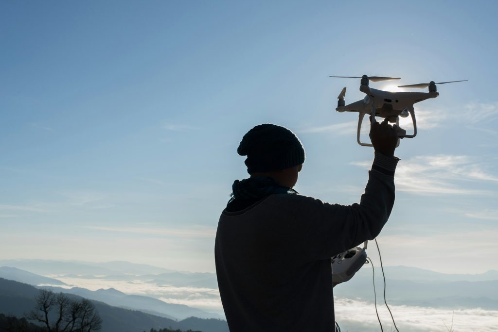 Men's hands hold the drone, pick it up - Innovaciones Tecnológicas en los Nuevos Modelos de Drones de DJI - Rocdron, Operadora profesional de drones en Navarra y entidad de formación