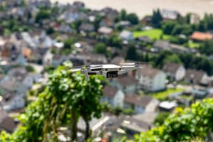 The drone hovers over the grape hills and countryside, the plastic propellers are on