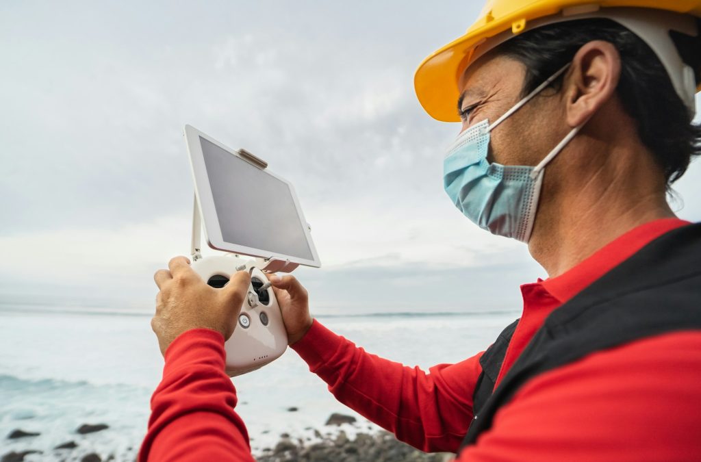 Hombre pilotando un dron: -¿Qué usos tiene las inspecciones técnicas con drones? - Roc Dron, operadora profesional de drones y formación.